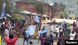 FILE - A still image taken from a video shot on Oct. 1, 2017, shows protesters waving Ambazonian flags in front of road block in the English-speaking city of Bamenda, Cameroon.