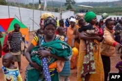 Nzeyimana Consolate, center, carries her baby as she arrives at the Nyabitara Transit site in Ruyigi, Burundi, Oct. 3, 2019.
