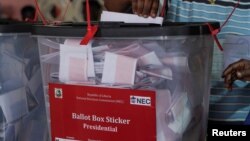 A woman casts her vote during Liberia's presidential election at a polling station in Monrovia, Oct. 10, 2023. 