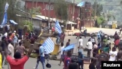 FILE - A still image taken from a video shot on Oct. 1, 2017, shows protesters waving Ambazonian flags in front of road block in the English-speaking city of Bamenda, Cameroon. 