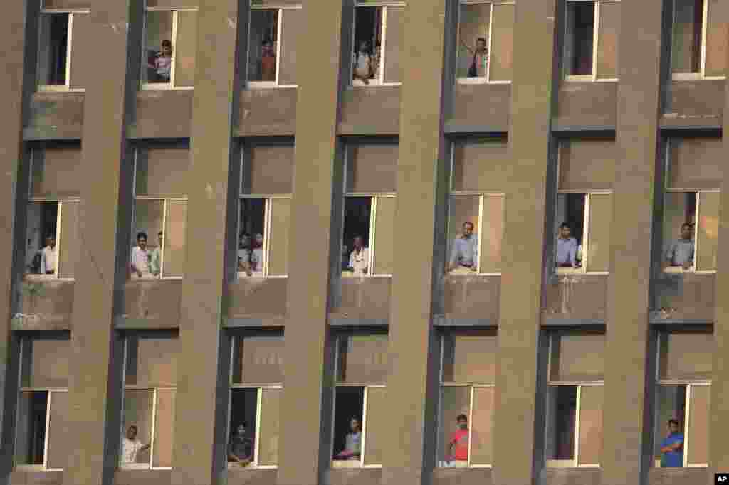 Bangladeshis watch the 2018 FIFA World Cup qualifying soccer match between Jordan and Bangladesh, from a building in Dhaka.
