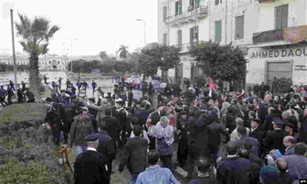 Egyptian anti-riot police officers flee, top left, as Egyptian lawyers in black robes gather near the square by Abdin palace, one of the Presidential palaces, background, in Cairo, Egypt, Thursday, Feb. 10, 2011. Labor unrest across the country gave power