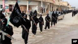 This undated file image posted on a militant website on Tuesday, Jan. 14, 2014 shows fighters from the al-Qaida linked Islamic State of Iraq and the Levant (ISIL) marching in Raqqa, Syria