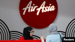 FILE - An AirAsia counter staff attends to a customer at Kuala Lumpur International Airport, Malaysia, Aug. 28, 2016. 