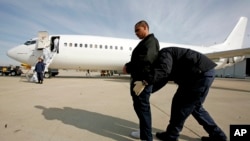 ARCHIVO - En esta foto de archivo del 14 de marzo de 2008, un agente de EE. UU. registra a Gerardo López Arellano, de 24 años, en el Aeropuerto Internacional O'Hare de Chicago antes de escoltarlo a un avión para su deportación a México . (AP Photo / Brian Kersey, Archivo). Un juez hizo regresar un vuelo con inmigrantes deportadas el jueves 9 de agosto de 2018, al enterarse de la deportación durante una audiencia. Las mujeres son demandantes en juicio contra el gobierno de EE.UU.