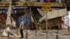 Seorang pria berdiri di depan sebuah toko yang rusak di Tel Aviv, setelah terkena roket yang ditembakkan militan Palestina dari Jalur Gaza hari Sabtu, 7 Oktober 2023.