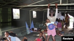 Flood victims wait at a relief center in Igbogene community in Bayelsa state, Nigeria, October 12, 2012.