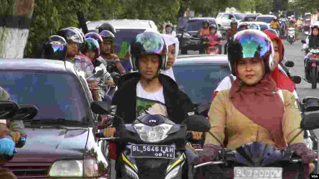 Women on motorcycles in Aceh can be stopped by special Shariah police if they are deemed not to be properly covered, Dec. 7, 2014. (Zinlat Aung/VOA)