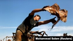 A Palestinian worker sorts metal waste in preparation for exporting, at a junkyard east of Gaza City. This picture was taken on January 25, 2021. REUTERS/Mohammed Salem