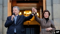 Ukrainian President Petro Poroshenko and his wife Maryna greet their supporters who had come to thank him for what he did as a president, in Kiev, Ukraine, Monday, April 22, 2019. (AP Photo/Vadim Ghirda)