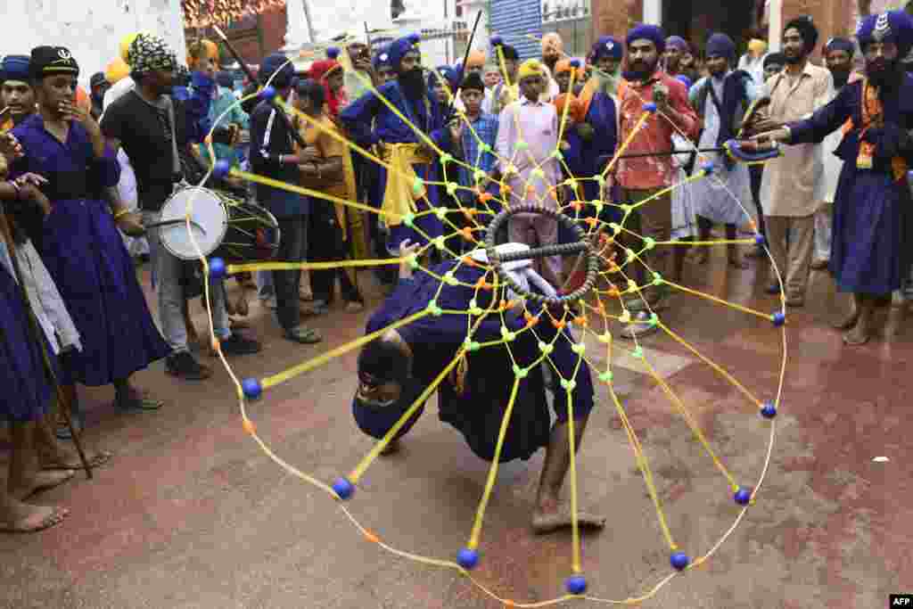 A youth performs the Sikh martial art known as &#39;Gatka&#39; on the occasion of the 417th anniversary of the installation of the Guru Granth Sahib, at the Golden Temple in Amritsar, India.