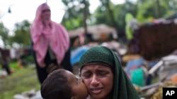 FILE - A Rohingya Muslim child kisses his mother as they rest after having crossed over from Myanmar to the Bangladesh side of the border near Cox's Bazar's Teknaf area, Sept. 2, 2017. Tens of thousands of others crossed into Bangladesh in a 24-hour span 