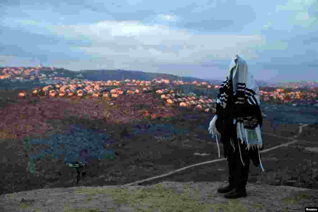 A Jewish man covered in a prayer shawl, prays in the Jewish settler outpost of Amona in the West Bank.