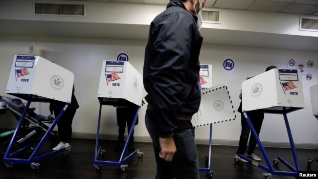 FILE - Voters fill out ballots in voting booths in the New York City election at a polling location in the Manhattan borough of New York, Nov. 2, 2021.