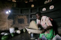 A woman prepare sorghum for food at her home in drought-hit Masvingo, Zimbabwe; REUTERS/Philimon Bulawayo