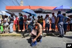 People affected by the passage of Hurricane Maria wait in line at Barrio Obrero to receive supplies from the National Guard, in San Juan, Puerto Rico, Sept. 24, 2017.
