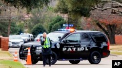 Law enforcement officials block a residential street near Congregation Beth Israel synagogue where a man took hostages during services Jan. 15, 2022, in Colleyville, Texas.