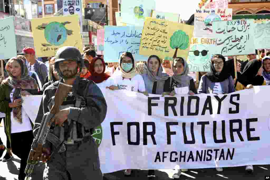 Young people attend a Climate Strike rally, as Afghan security forces guard them in Kabul, Afghanistan, Friday, Sept. 20, 2019. In the Afghan capital, where people are dying every day in horrific bomb attacks, a young generation, worried that if war doesn&#39;t kill them climate change will, took part in the global climate strike. (AP Photo/Ebrahim Noroozi)