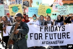 Young people attend a Climate Strike rally, as Afghan security forces guard them in Kabul, Afghanistan, Friday, Sept. 20, 2019. (AP Photo/Ebrahim Noroozi)