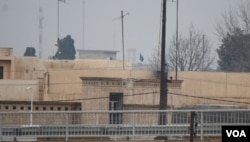 From a rooftop in western Mosul, an Islamic State flag can be seen waving in the militant-controlled area in Mosul, Iraq, March 2, 2017. (H. Murdock/VOA)