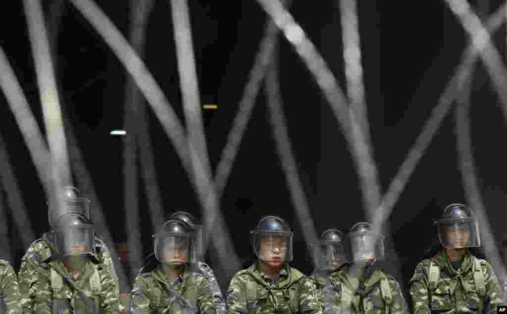 Thai soldiers stand behind barbed wire waiting for marching farmers demanding payment of a rice subsidy program from the government in Bangkok, Feb. 10, 2014.