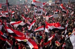 FILE- Egyptians wave national flags and hold pictures of Egypt's Defense Minister Gen. Abdel-Fattah el-Sissi, during a rally in Tahrir Square, in Cairo, Egypt, Saturday, Jan. 25, 2014. (AP Photo/Khalil Hamra)
