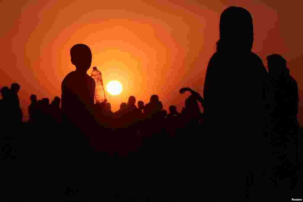 Iraqis who fled violence in Mosul gather as they reach Syria, near the Iraqi border.