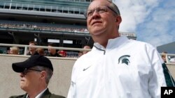FILE - Michigan State University Athletic Director Mark Hollis, right, and president Lou Anna Simon watch the action during an NCAA college football game in East Lansing, Michigan, Sept. 24, 2016. 