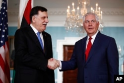 Secretary of State Rex Tillerson shakes hands with Libyan Prime Minister Fayez al-Sarraj during a media opportunity at the State Department in Washington, Dec. 1, 2017.