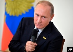 Russian President Vladimir Putin speaks to Russian journalists during a news conference following the BRICS summit in Goa, India, Oct. 16, 2016. Putin is denying allegations of Russian government interference with the U.S. election process.