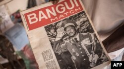 Un vendeur de souvenirs présente le premier numéro de l'hebdomadaire "Bangui Match" portant la photo de Bokassa, à Bangui, le 17 septembre 2019.