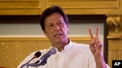 Pakistani opposition politician Imran Khan, chief of the Pakistan Tehreek-e-Insaf party, gives the victory sign during a press conference to present the party's manifesto for the forthcoming election, in Islamabad, Pakistan, July 9, 2018.