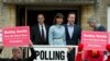 Britain's Prime Minister and Conservative Party leader David Cameron and his wife Samantha leave a voting station in Spelsbury, England, as protesters demonstrate outside after they voted in the general election, May 7, 2015. 