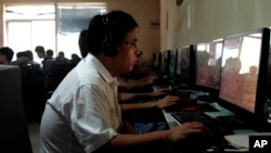 Un hombre chino utiliza una computadora en un café de Internet en Beijing. Los comunistas de China están aumentando los controles ya estrictos sobre el uso de Internet.