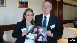 Melissa Rhodes-Smith and Geoff Rhodes hold a photo of Gavin Rhodes and his wife, Phoumalaysy and their children, in Vientiane, Laos, Nov. 28, 2014. (Ron Corben/VOA)