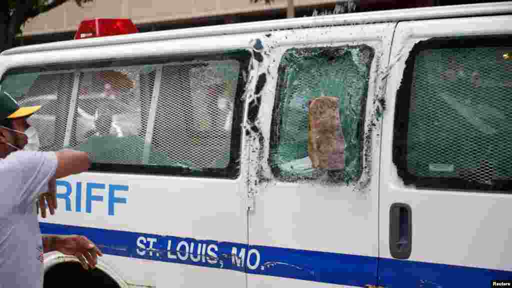 A demonstrator throws a brick at a sheriff van during a protest in St. Louis, Missouri, June 1, 2020, against the death African-American man George Floyd in Minneapolis police custody.