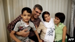 FILE - Iranian lawyer Nasrin Sotoudeh poses with her husband, Reza Khandan, her son Nima (L) and her daughter Mehraveh (R ) at her house in Tehran on Sept. 18, 2013, after being freed after three years in prison.