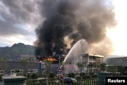 FILE - Rescue workers try to put out a fire after an explosion at a chemical plant inside an industrial park in Yibin, Sichuan province, China July 12, 2018.