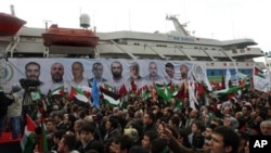 People holding Turkish and Palestinian flags cheer as the Mavi Marmara ship, in the background, the lead boat of a flotilla headed to the Gaza Strip which was stormed by Israeli naval commandos in the Mediterranean May 31, 2010, returns to Istanbul, Turkey.