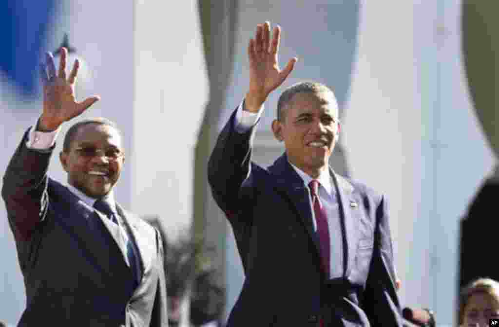 U.S. President Barack Obama, right, and Tanzanian President Jakaya Kikwete, left, wave as they enter State House, in Dar es Salaam, Tanzania Monday, July 1, 2013. Teeming crowds and blaring horns welcomed President Barack Obama to Tanzania's largest city