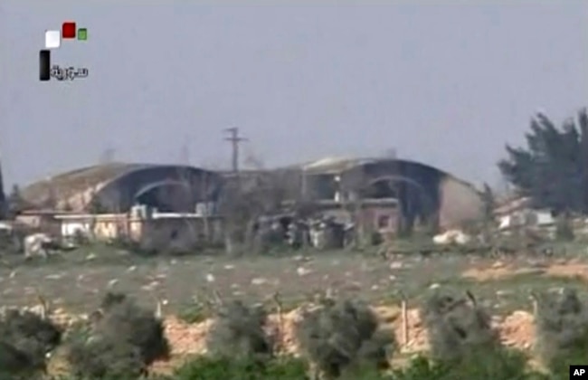 FILE - This frame grab from video provided April, 7, 2017, by official Syrian TV shows the burned and damaged hangars hit by U.S. Tomahawk missiles at the Shayrat air base southeast of Homs, Syria. Syrian warplanes resumed flights from the air base Sunday, a Syrian regional official claimed.