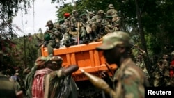 FILE - M23 rebels sit in a vehicle as they withdraw from the eastern Congo town of Goma, Dec. 1, 2012..