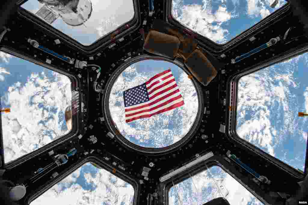 An American flag is visible in the windows of the cupola aboard the International Space Station. Thanks to a bill passed by Texas legislators in 1997 that put in place technical voting procedure for astronauts &ndash; nearly all of whom live in Texas &ndash; they have the ability to vote from space through specially designed absentee ballots. To preserve the integrity of the secret vote, the ballot is encrypted and only accessible by the astronaut and the county clerk responsible for casting the ballot.