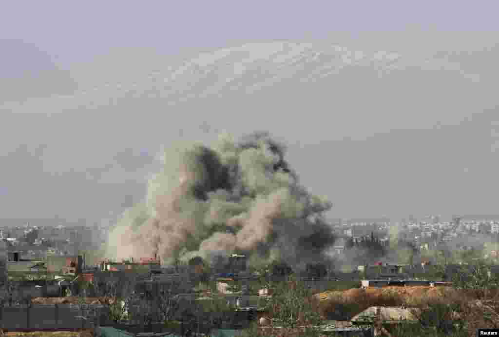 Smoke rises after what activists describe as barrel bombs are dropped by government forces in Daraya, near Damascus, Jan. 31, 2014. 