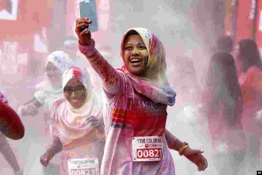 A participant takes a selfie as she runs through a &quot;color station&quot; during the five-kilometer color run event in Kuala Lumpur, Malaysia.