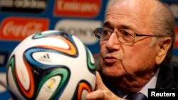 FIFA President Sepp Blatter holds an official 2014 FIFA World Cup soccer ball during a media conference in Sao Paulo, Brazil, June 5, 2014.