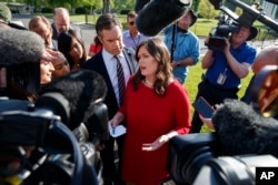 FILE - White House press secretary Sarah Sanders talks to reporters outside the White House, May 3, 2018.