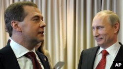 Russian President Vladimir Putin, right, and Prime Minister Dmitry Medvedev attend the United Russia party annual congress in Moscow, May 26, 2012.