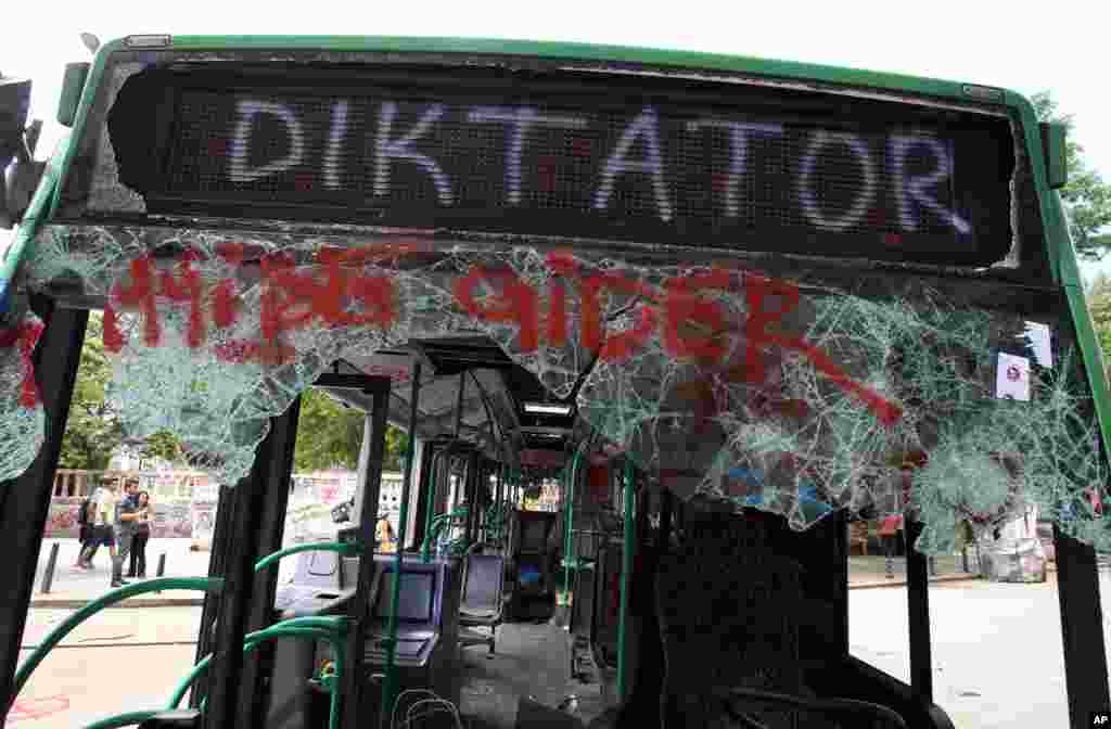 People observe a destroyed urban bus with a destination sign that reads &#39;&#39;This bus goes to Dictator&#39;&#39; at Taksim Square, Istanbul, June 6, 2013. 