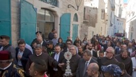 Christian clergymen carry a wooden relic believed to be from Jesus' manger outside the Church of the Nativity, traditionally believed by Christians to be the birthplace of Jesus Christ, in the West Bank city of Bethlehem, Saturday, Nov. 30, 2019.
